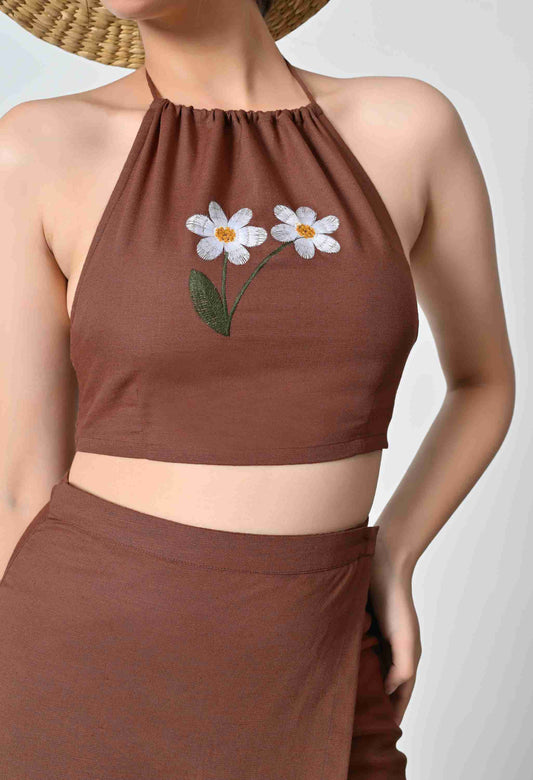 Brown halter top with floral embroidery on a plain background
