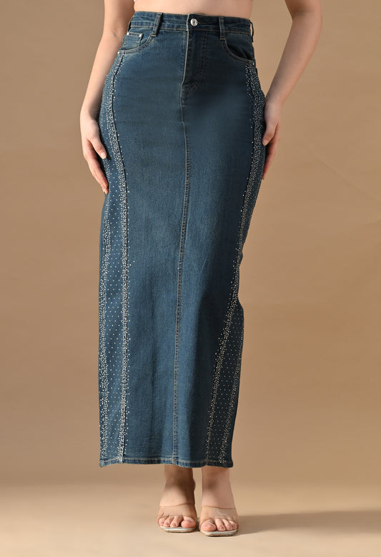 Long denim skirt worn by a person on a beige background