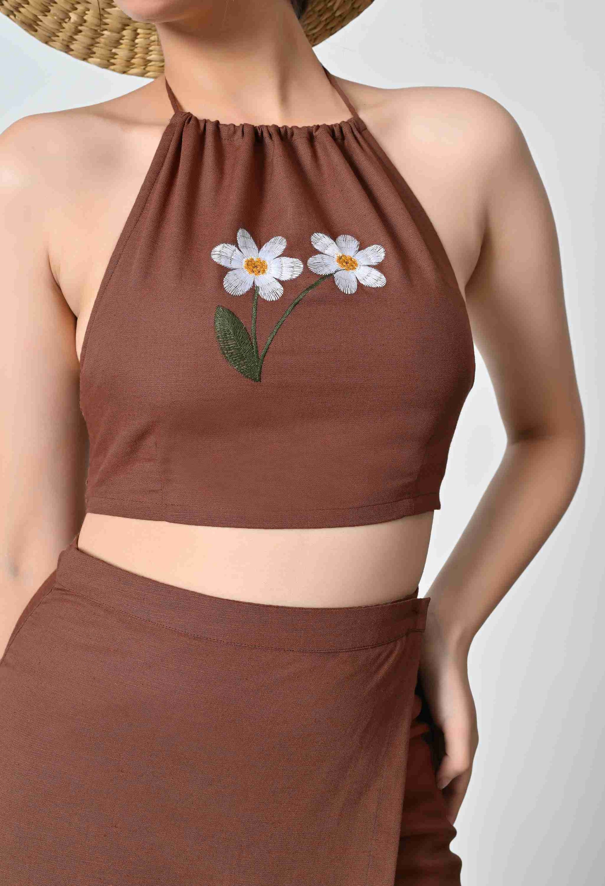 Brown halter top with floral embroidery on a plain background