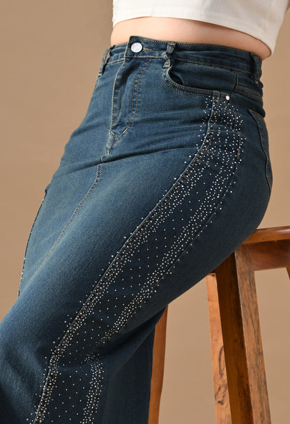 Blue jeans with decorative studs on a brown background