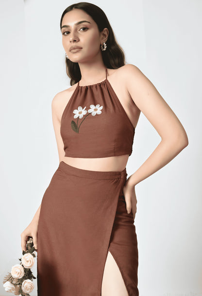 Woman wearing a brown outfit with floral details on a white background