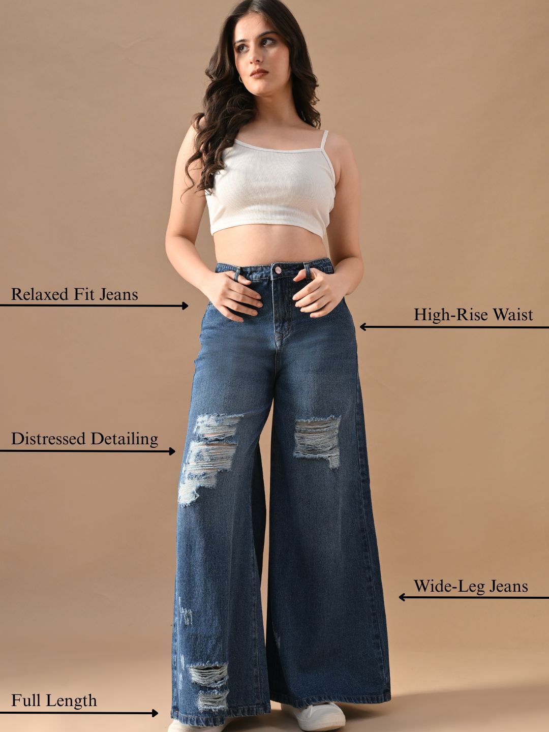 Woman wearing blue wide-leg jeans with text labels on a beige background
