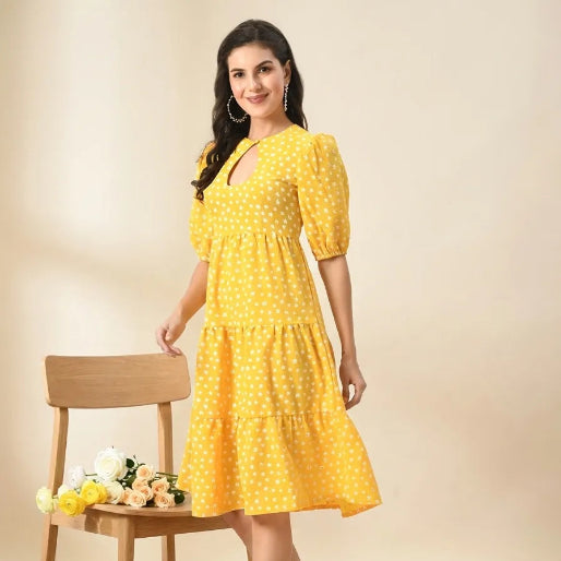 Woman in a yellow dress standing next to a wooden chair with flowers on a beige background